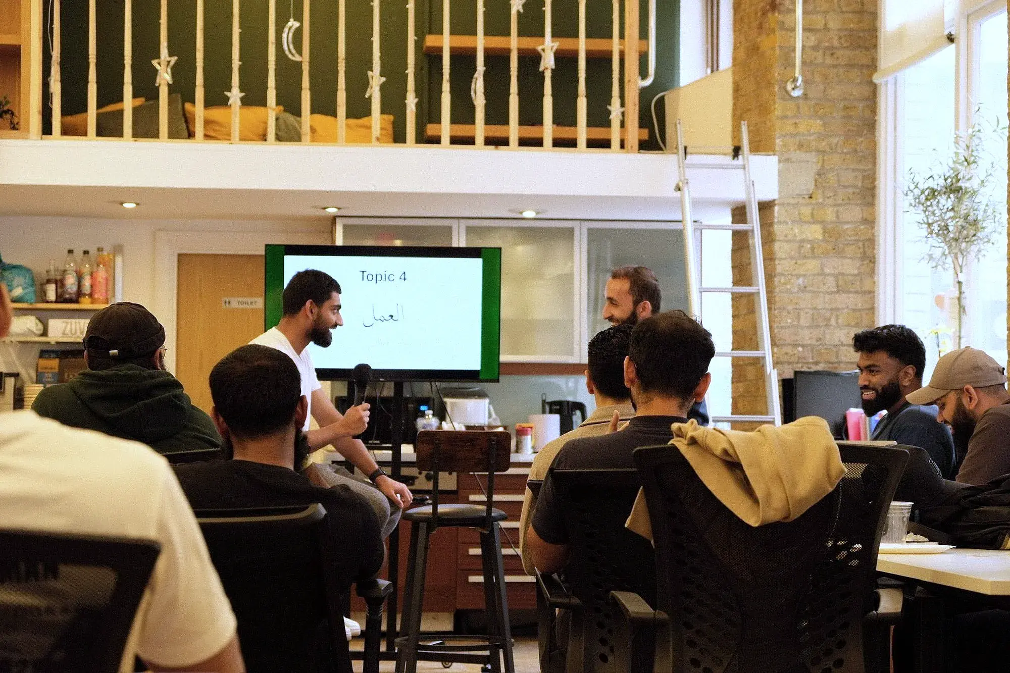 Students at an Arabic Conversations session, gathered round a lesson on screen