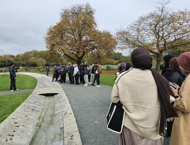 Students gathered in a London park on a community walk