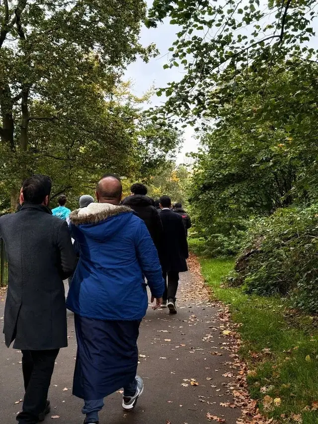 Students walking a park path together in autumn