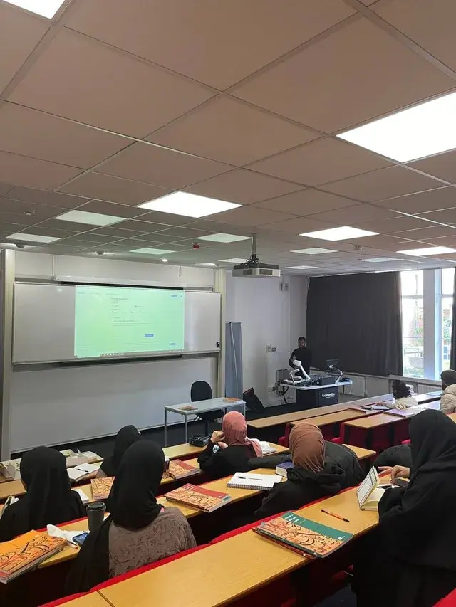 A lecture hall session, students working from their books